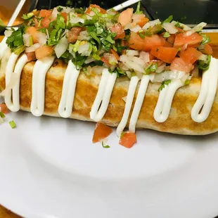 a hot dog with toppings on a white plate