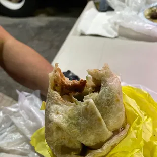 a hand holding a taco