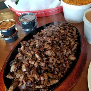 1 lb sizzling carne asada, comes w rice/beans, fresh tortillas, cilantro, onion, salsa $22.99 (4/23/21). Fed 3 of us!