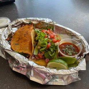 Birria taco (left), chicken taco, and birria sauce (little bowl on the right).