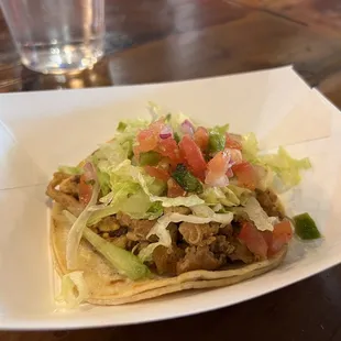 a taco with lettuce and tomatoes