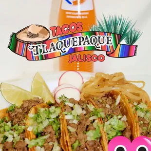 a plate of tacos and a bottle of taco sauce