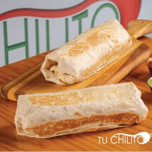 two burritos on a cutting board