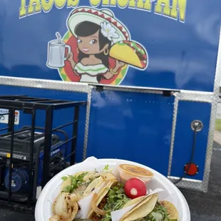 a person holding a plate of tacos