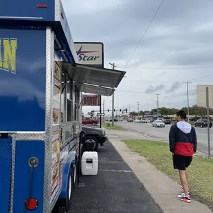 a man standing in front of a taco truck