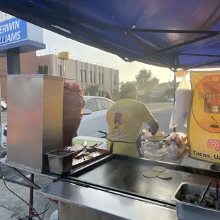 a man preparing food at a food stand