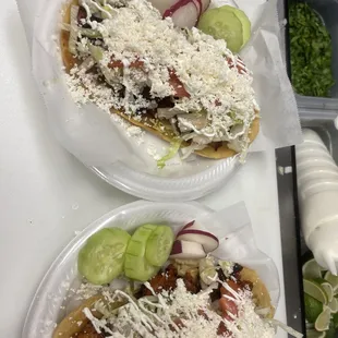 two plates of tacos with toppings