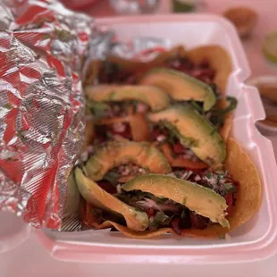 a plate of tacos with avocado