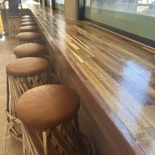 a row of stools in front of a window