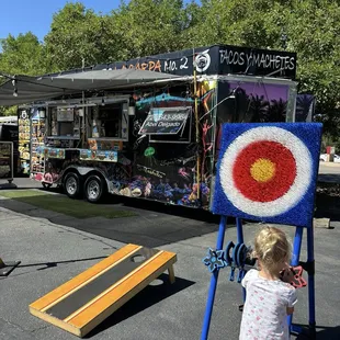 Large parking lot had 2 sets of cornhole and a plastic axe throwing game, in addition to 2 picnic tables with umbrellas
