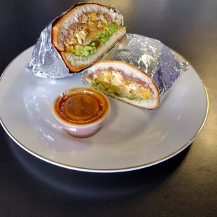 a plate with a burrito and sauce