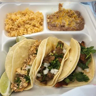 a tray of tacos and rice