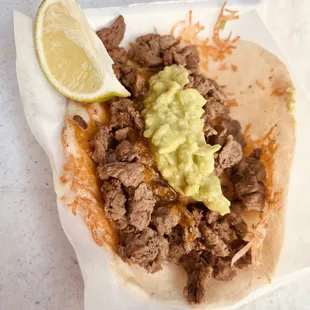 a taco with meat and guacamole