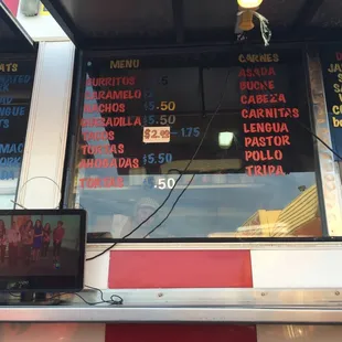 Watching El Gordo y La Flaca on TV, wooden tortilla press in the window