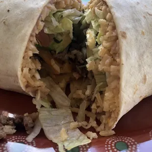 Close up: Cali Burrito with lots of carbs! Rice, fries, and some avocado with a little meat.