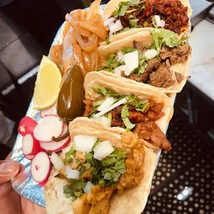 a person holding a plate of tacos