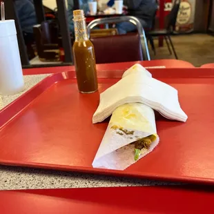 a burrito on a red tray at a restaurant