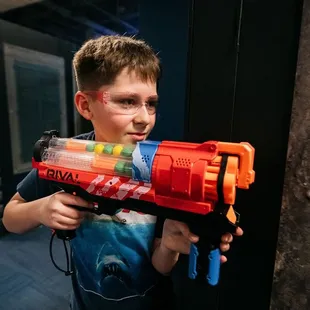 Focused and ready, a young player targets victory at Tactical Urban Combat - where play meets precision!