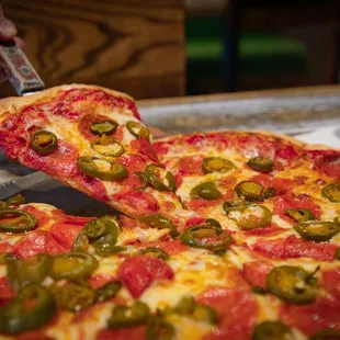 a person cutting a pizza with a knife