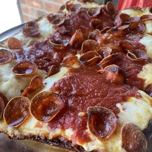 a pepperoni pizza on a pan