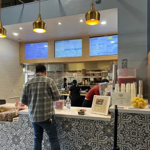 a man standing at a counter in a restaurant