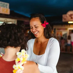 Tahitian Treasures employee teaching guest how to tie a pareu
