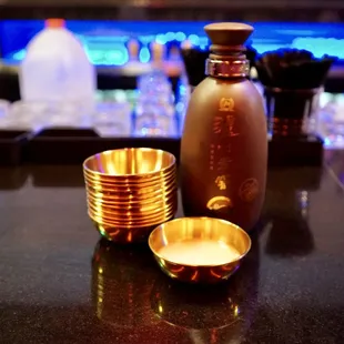 a shot of a gold cup and a bottle on a bar counter