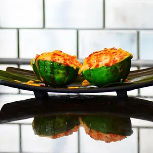 two stuffed green peppers on a plate