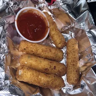 a plate of fried fish sticks and a bowl of ketchup