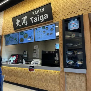 a woman standing in front of a food counter