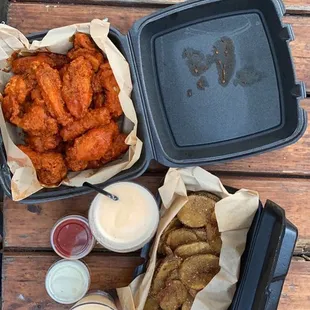 two trays of chicken wings and dipping sauces