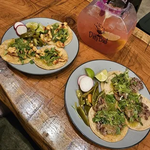 two plates of tacos and a drink