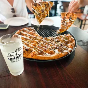  person taking a slice of pizza