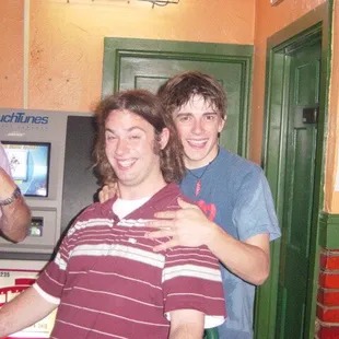 two men standing in a bar