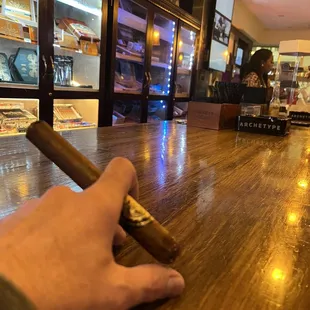 a hand holding a cigar