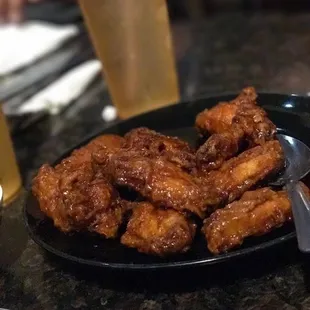 a plate of chicken wings and a glass of beer