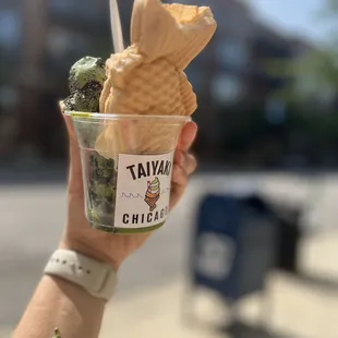 a hand holding a cup of ice cream