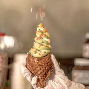 a hand holding an ice cream cone