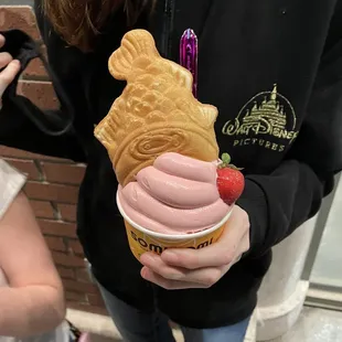 a person holding a cup of ice cream