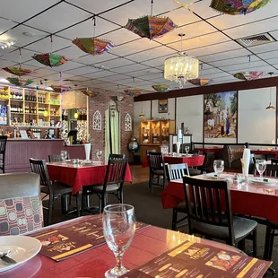 tables with red tablecloths and umbrellas hanging from the ceiling