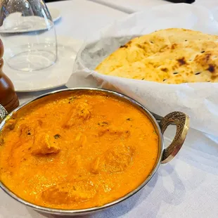 a bowl of curry and a plate of naan bread