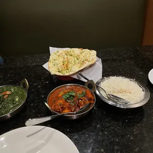 Spicy chili garlic naan (back middle), sag paneer (left), chicken spicy vindaloo (right), and rice