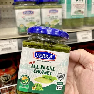 a hand holding a jar of pickle