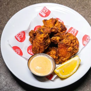 a plate of fried chicken with dipping sauce