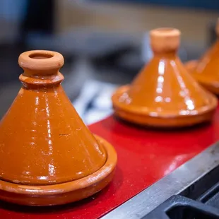 a close up of a row of tajines on a conveyor belt