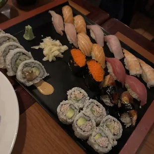 a variety of sushi on a black plate