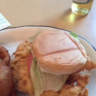 a fried chicken sandwich and onion rings