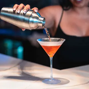 a woman pouring a cocktail