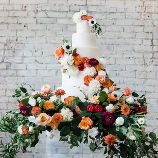 a white wedding cake with orange and white flowers