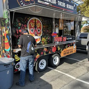 a man standing in front of a food truck
